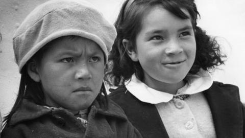 circa 1960: Two little girls displaying opposing emotions