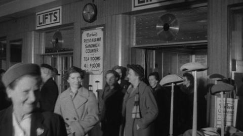 Crowds of people walk out of lifts