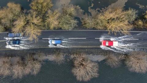 Cars driving through flooded road