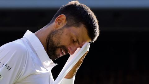 Novak Djokovic wipes his face during his Wimbledon semi-final loss to Jannik Sinner