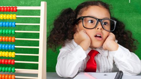 Young student looking confused next to an abacus