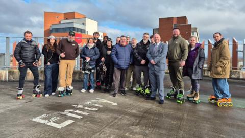 A group of people wearing roller skates on the top of a car park