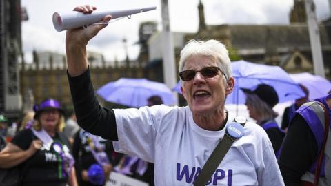 Waspi campaigners outside Parliament wearing badges and t-shirts about their campaign.