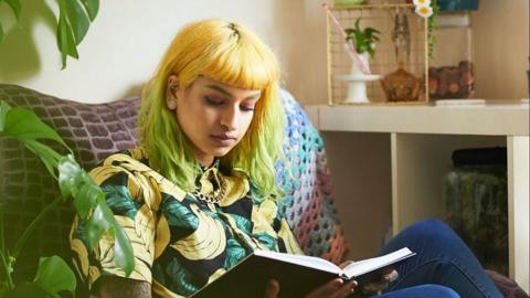 Young person reading a book relaxing.