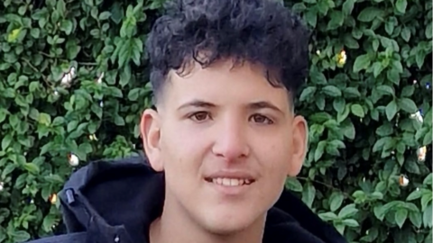 Ahmad Mamdouh Al Ibrahim looks at the camera. He has curly black hair and is wearing a black hooded coat