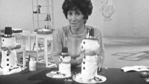 Valarie Singleton sits at a table with snowman table decorations on it