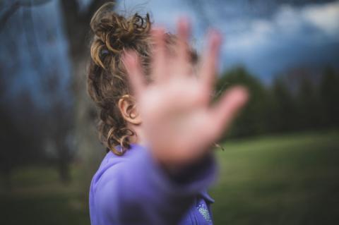 Child shielding their face from the camera with their hand