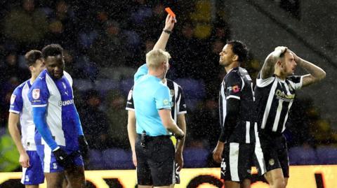 Notts County's Oliver Norburn (second from right) is shown a red card by the referee in the Magpies defeat by Oldham on Tuesday