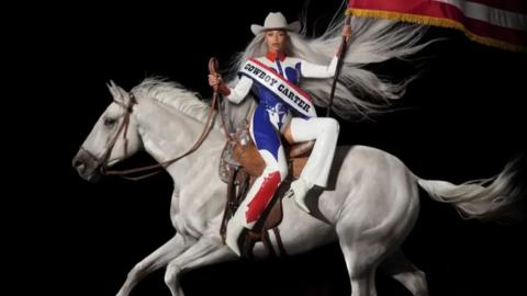 Artwork showing Beyonce in an Evil Knievel style outfit, a white cowboy hat waving the US flag while riding a white horse