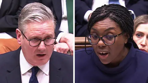 Starmer and Mandelson stood next to each other in suits, smiling.