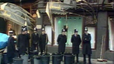 A group of policemen stand in front of Harrods after the bombing