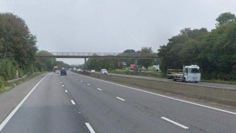 A shot of the M4 motorway. A bridge can be seen crossing over the carriageways.