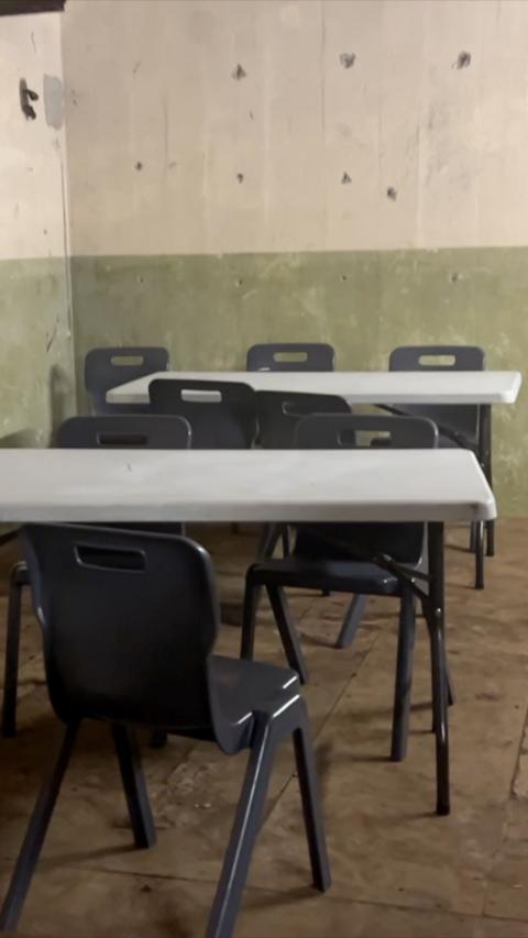 Grey and black tables and chairs set up in an underground bunker