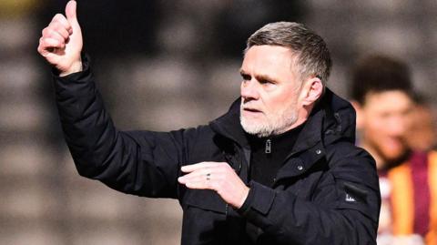 Bradford City boss Graham Alexander gives a thumbs up to fans