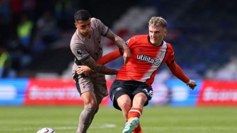 Alfie Doughty of Luton Town in action with Pedro Porro of Tottenham Hotspur during the Premier League match between Luton Town and Tottenham Hotspur