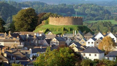 Totnes Castle with its round exterior appears on a hill above the town of Totnes