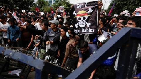 Demonstrators try to break through police barricades in Kathmandu during a protest against corruption and the government's decision to ban several social media platforms