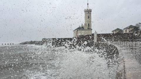 Waves crash onto a sea wall in Scotland