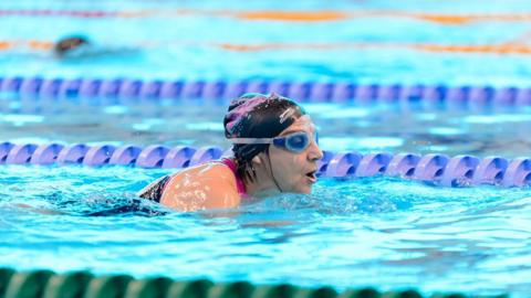 Woman swimming at a public pool