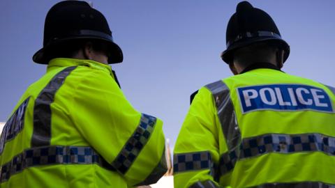 A generic picture of two police officers standing outside against a blue sky.