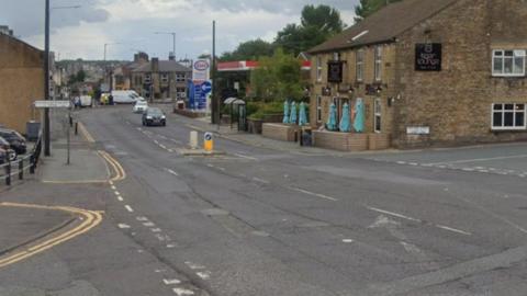 Road surface in need of repair at a crossroads in Lancashire.