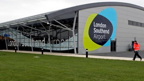 The outside of London Southend Airport, a large modern building with "London Southend Airport" written in large letters on the side. 