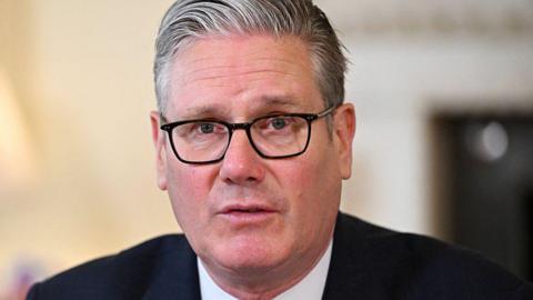 Keir Starmer wearing a suit and glasses