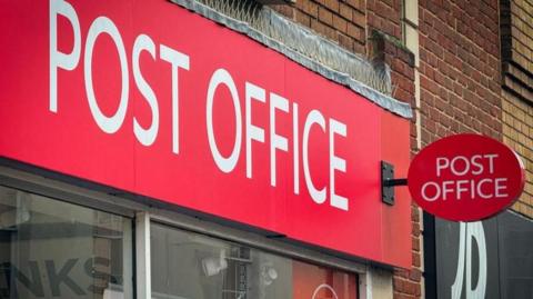 A Post Office branch sign on a UK High Street