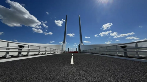 The new Gull Wing Bridge in Lowestoft, showing road with metal railings on either side and vertical wing structures at the end