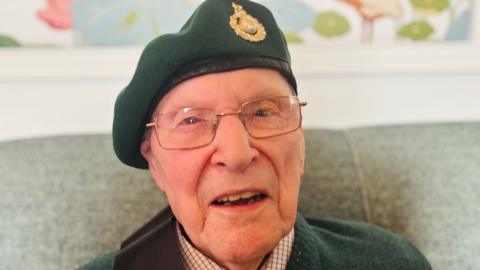 Army veteran Sandy Calder wearing a green army beret and looking at the camera.