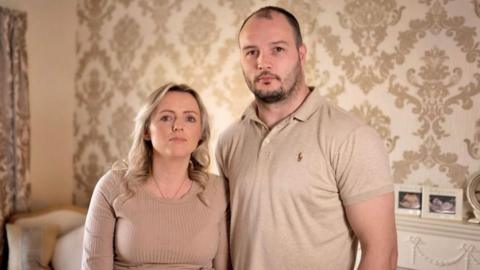 A woman and a man stand next to each other.