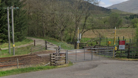 A railway crossing with metal gates on each side