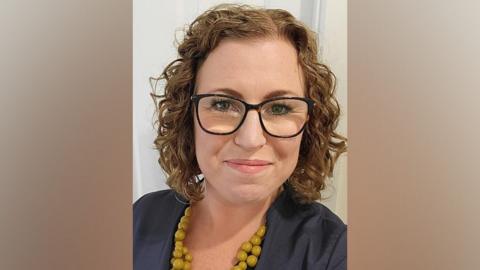 Nicola Zurawliw, a Nottinghamshire Healthcare nurse, wearing glasses, a blue top and yellow beads