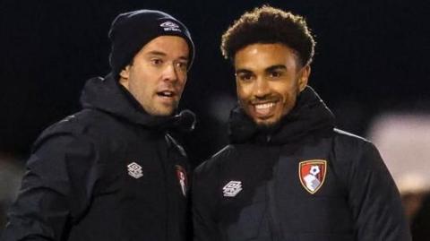 Junior Stanislas, on the right, stands on the touchline with Bournemough Under-18s head coach James Lowy during an FA Youth Cup tie