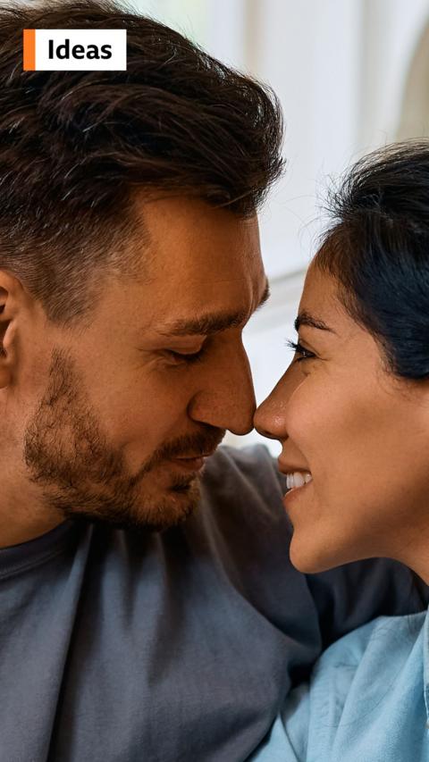 Woman and man smiling as they are about to kiss