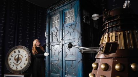 Various Doctor Who props, including a cracked Tardis, Dalek and a clock.