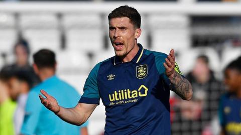 Josh Ruffels appeals to the referee during a match for Huddersfield Town