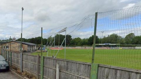 Exterior shot of a recreation ground with a pavilion and football goal posts