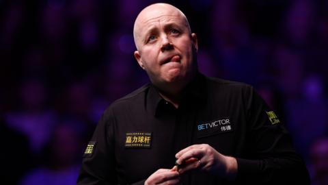 Snooker player John Higgins bites his tongue 
