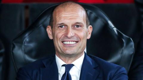 Massimiliano Allegri smiling on the bench while Juventus manager
