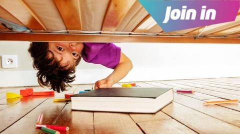 A child looking under the bed.