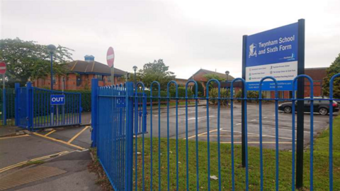 Outside the blue school gates of Twynham School.