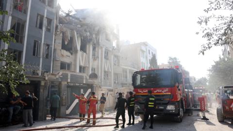 Emergency workers around a building in Tehran that was damaged during Israeli air strikes.
