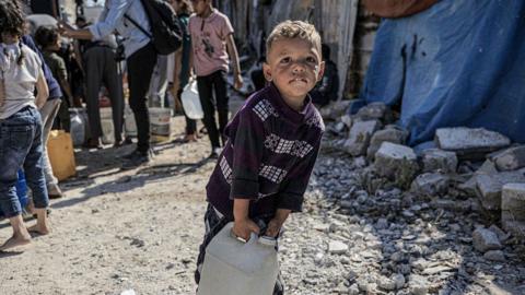 Palestinians receive clean drinking water, distributed by a water tanker, as they face difficulties in accessing water due to the ongoing Israeli attacks in Gaza City, Gaza 