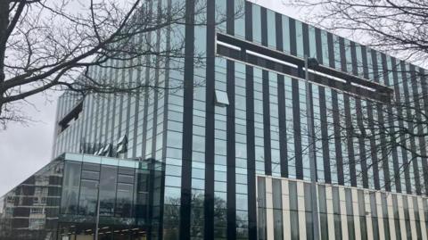 A large glass building with hundreds of square glass windows.