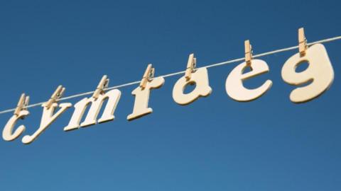 The Welsh-language word for Welsh, Cymraeg, with the letters on a clothes line.