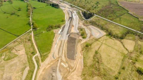 Aerial shot of Kex Gill work with fields and part of the road being built. 