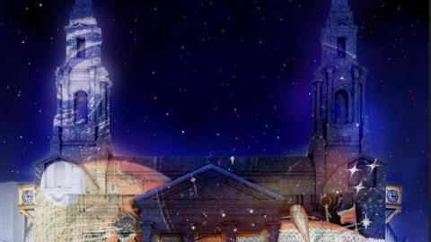 A light display projected to the walls of Leeds Civic Hall. The night sky is filled with stars. 