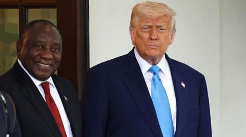 South African President Cyril Ramaphosa, seen wearing a black suit and red tie, stands next to his US counterpart to his right, Donald Trump, who is seen wearing a navy blue suit and blue tie