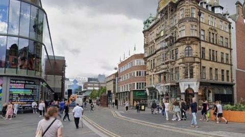 Dozens of people walking up and down Blackett Street. Eldon Square shopping centre can partly be seen on the lefthand side, with Waterstones and Fenwick on the right.